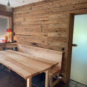 Verkleidung einer Küchenecke mit Altholzschalung, dazu passend eine Eckbank mit Esstisch in Esche astig, geölt